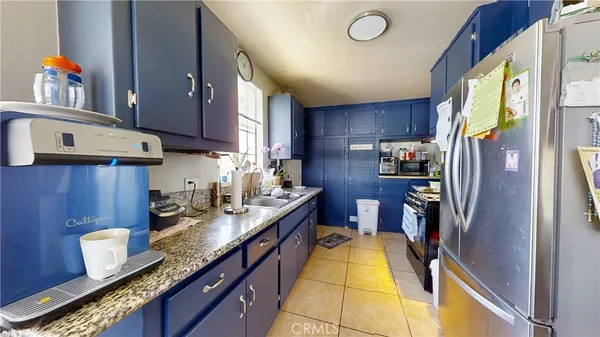 a kitchen with granite countertop a sink stove and refrigerator