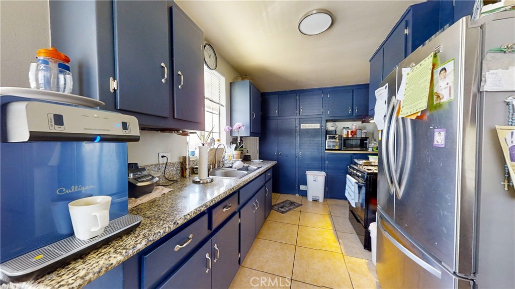 13226 Paxton Street Pacoima, CA 91331 - Photo 16 of 27 a kitchen with granite countertop a sink stove and refrigerator