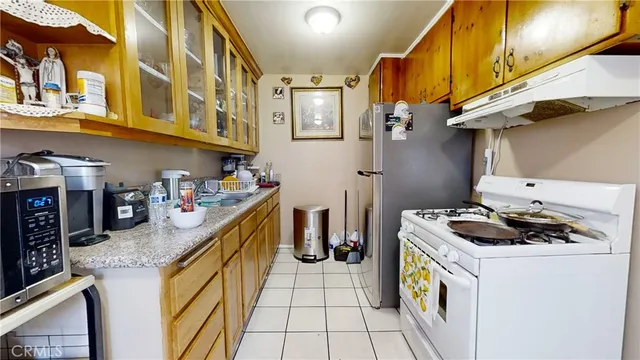 a kitchen with stainless steel appliances granite countertop a sink a stove and a wooden cabinets