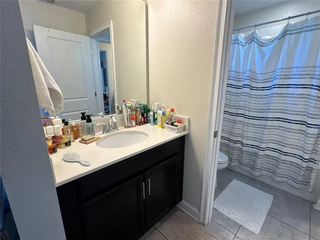 a view of a tennis ground with large trees