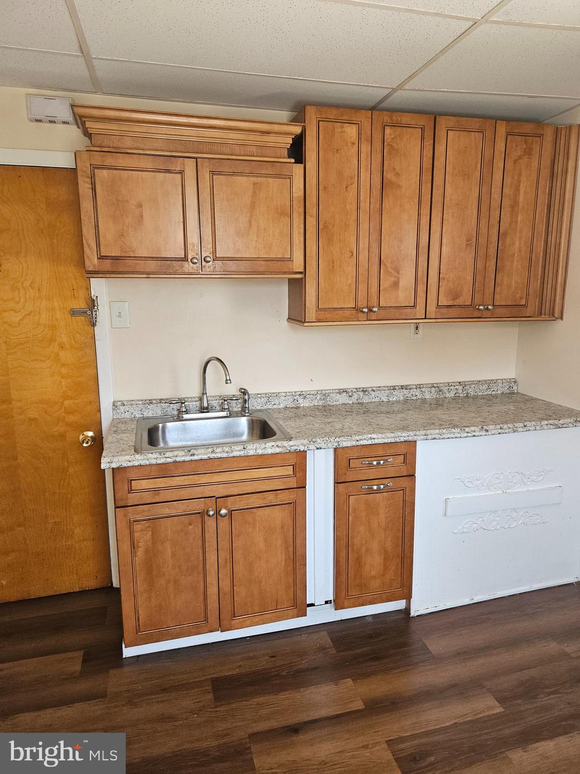 a kitchen with granite countertop wooden cabinets a sink and dishwasher