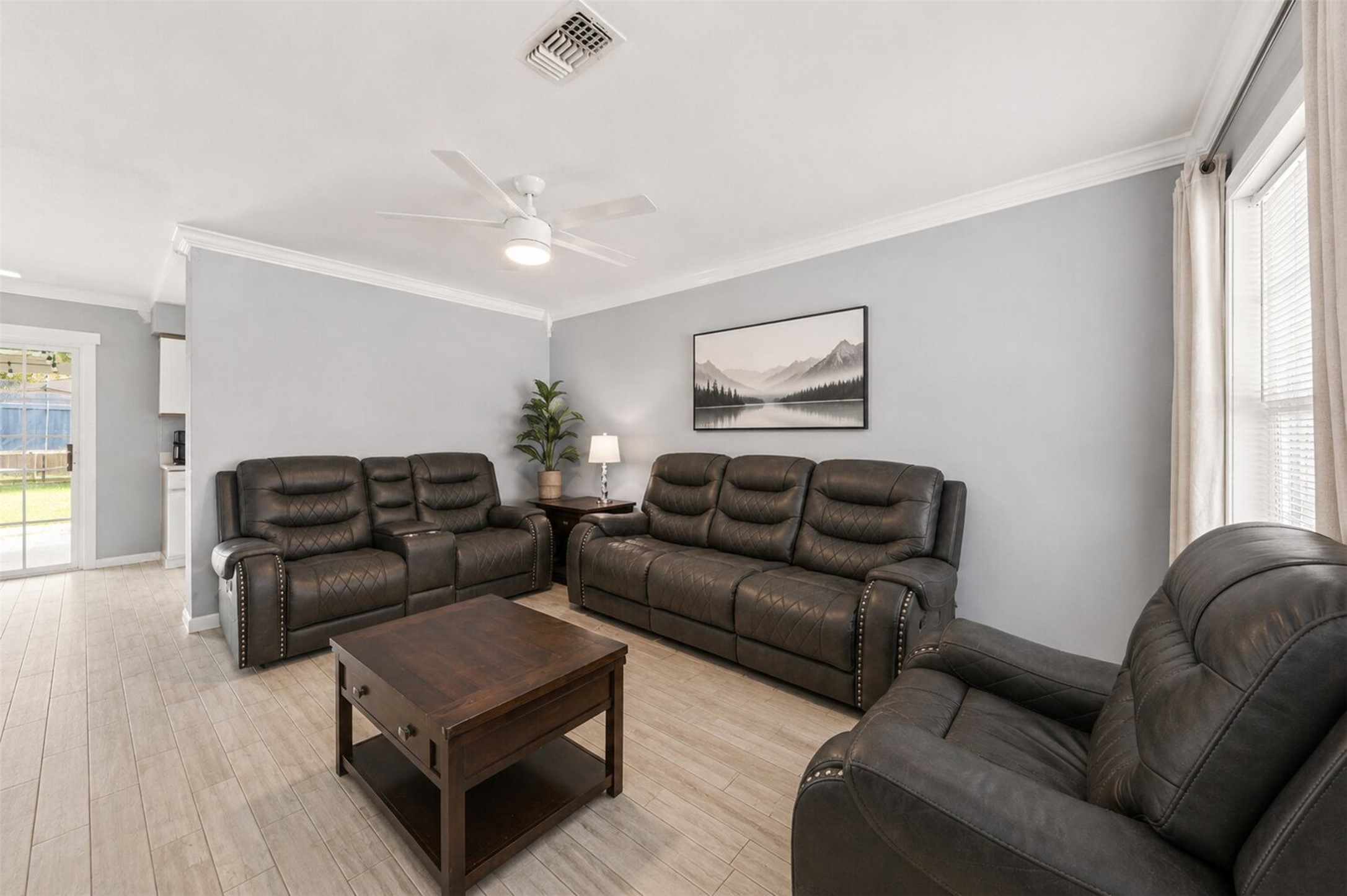 1306 Camden Road Pasadena, TX 77502 - Photo 4 of 16 Spacious living room with an open layout, crown molding, ceiling fan, and plenty of natural light flowing in a warm and comfortable space to call home!
