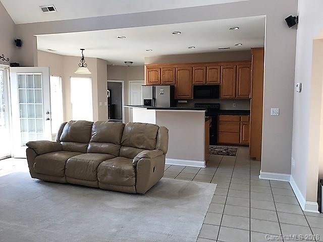 211 Trinity Church Road Monroe, NC 28112 - Photo 12 of 27 a living room with furniture a kitchen and a refrigerator