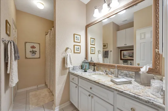 a bathroom with a granite countertop sink and a mirror