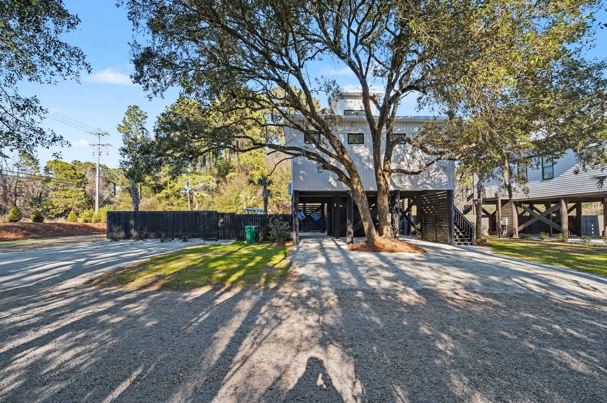 236 Brown Pelican Loop Pawleys Island, SC 29585 - Photo 1 of 38 View of front facade featuring a carport, stairs, and driveway
