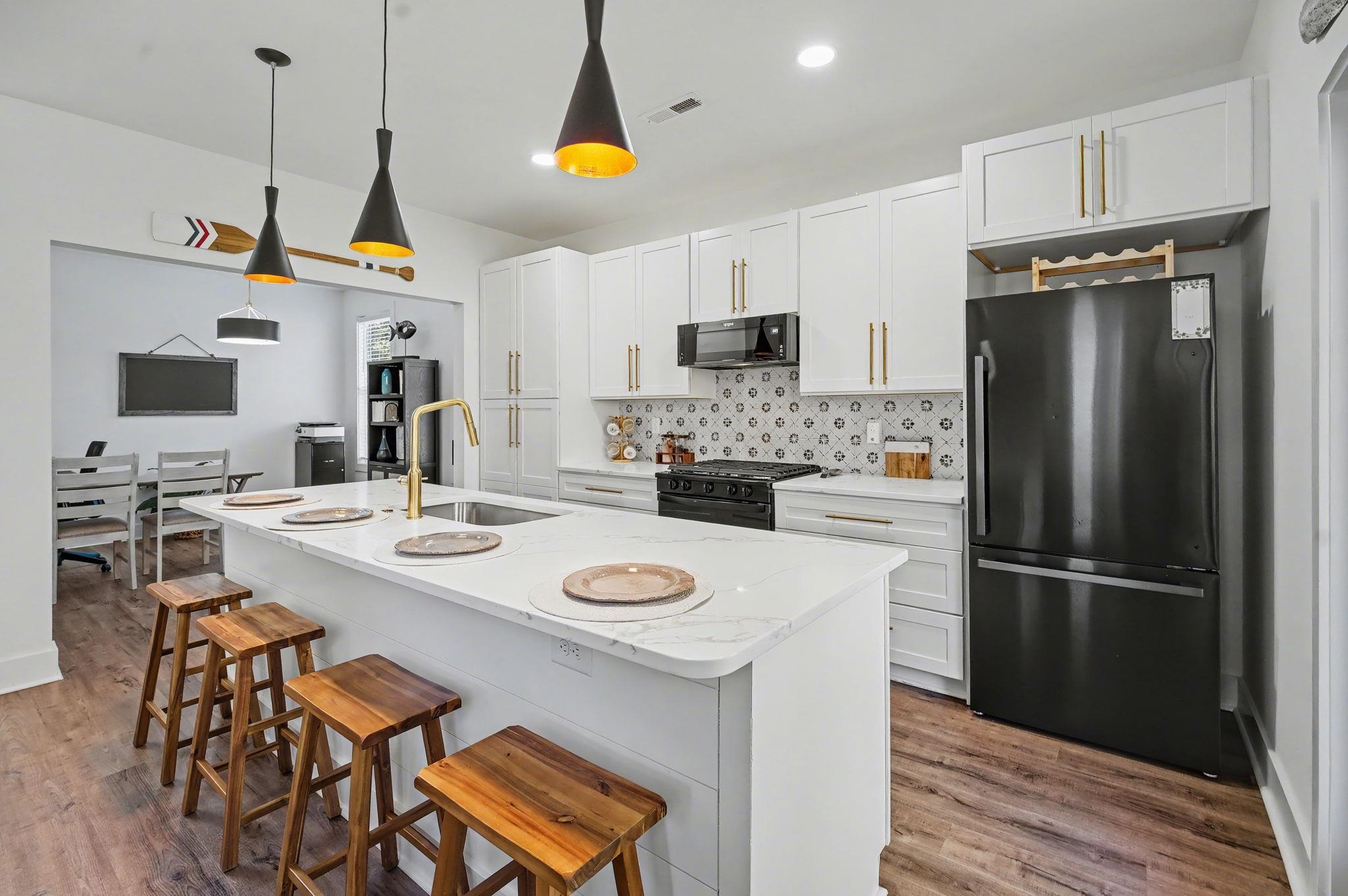 236 Brown Pelican Loop Pawleys Island, SC 29585 - Photo 18 of 38 Kitchen featuring black appliances, a kitchen bar, hanging light fixtures, white cabinetry, and recessed lighting