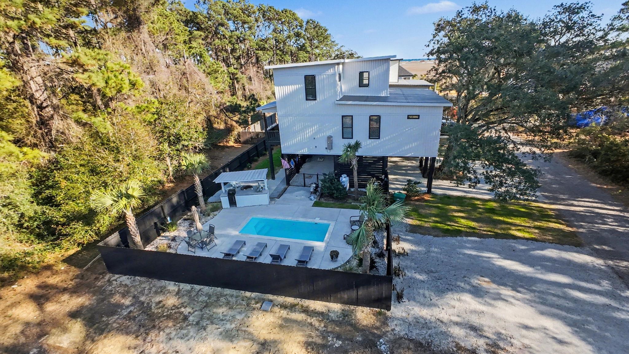236 Brown Pelican Loop Pawleys Island, SC 29585 - Photo 2 of 38 Side view of property featuring stairs, a fenced backyard, and a patio