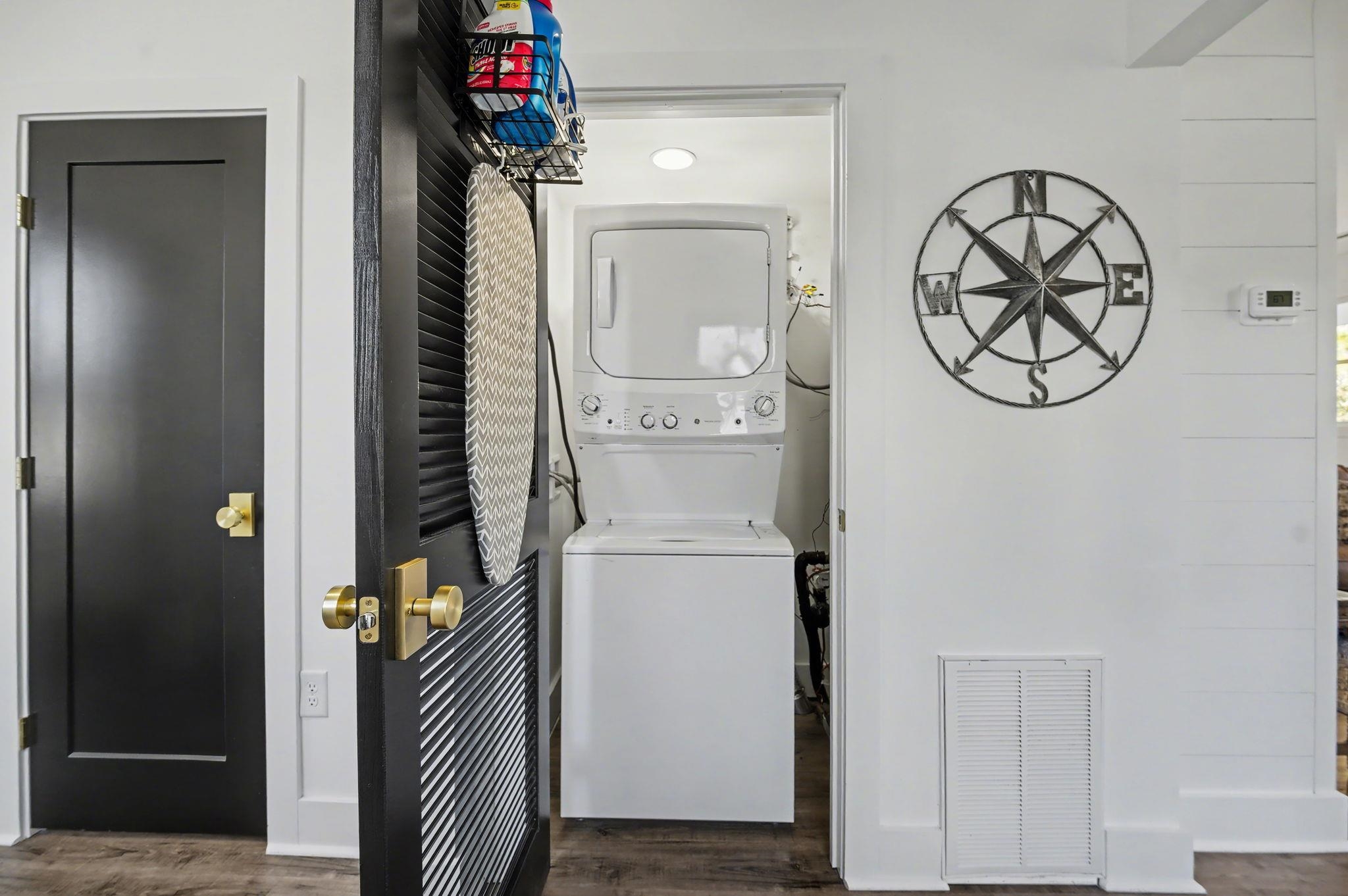236 Brown Pelican Loop Pawleys Island, SC 29585 - Photo 23 of 38 Laundry room featuring stacked washer / dryer and dark wood-type flooring