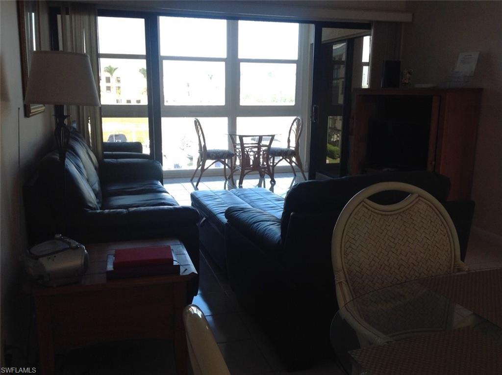 803 River Point Drive, Unit 202B Naples, FL 34102 - Photo 11 of 24 a living room with furniture and a floor to ceiling window
