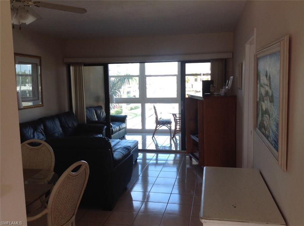 803 River Point Drive, Unit 202B Naples, FL 34102 - Photo 12 of 24 a living room with furniture and a floor to ceiling window