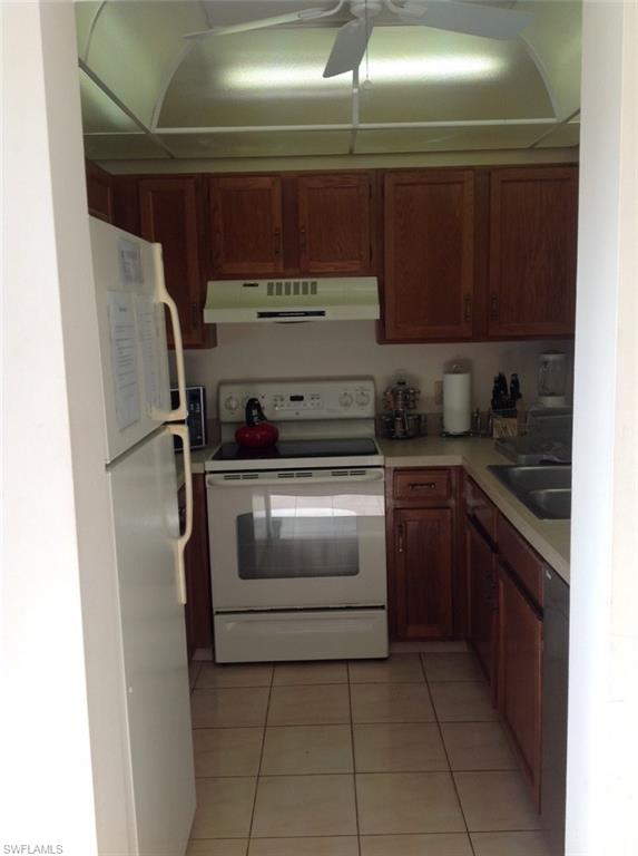803 River Point Drive, Unit 202B Naples, FL 34102 - Photo 14 of 24 a kitchen with a stove and a refrigerator