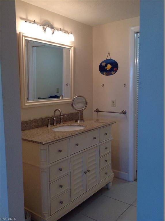803 River Point Drive, Unit 202B Naples, FL 34102 - Photo 15 of 24 a bathroom with a granite countertop sink and a mirror