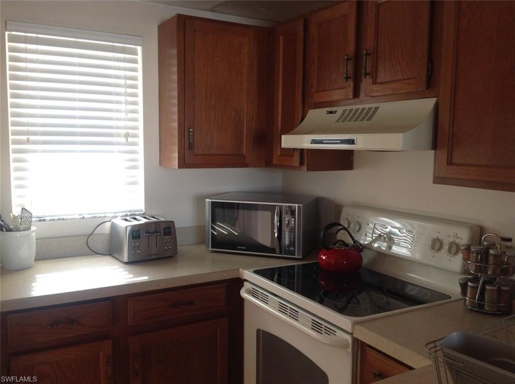 803 River Point Drive, Unit 202B Naples, FL 34102 - Photo 22 of 24 a kitchen with a stove and a refrigerator