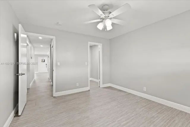 an empty room with wooden floor and mirror