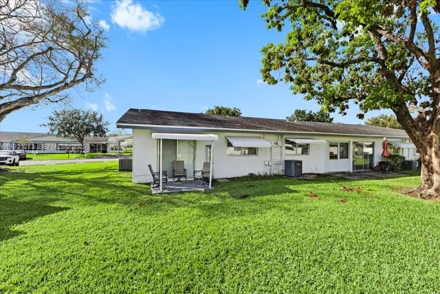 a view of a house with a yard and sitting area