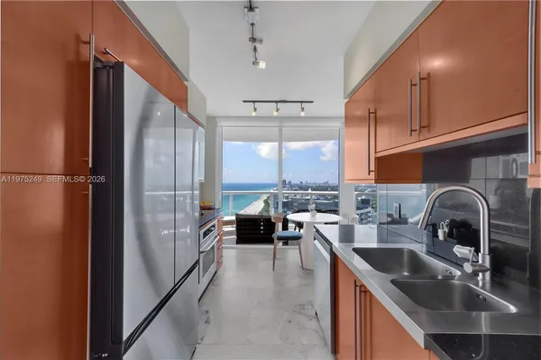 a kitchen with a refrigerator a sink and cabinets