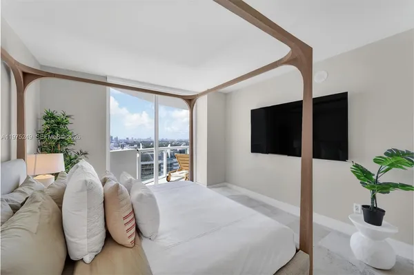 a bedroom with a large bed and a large window