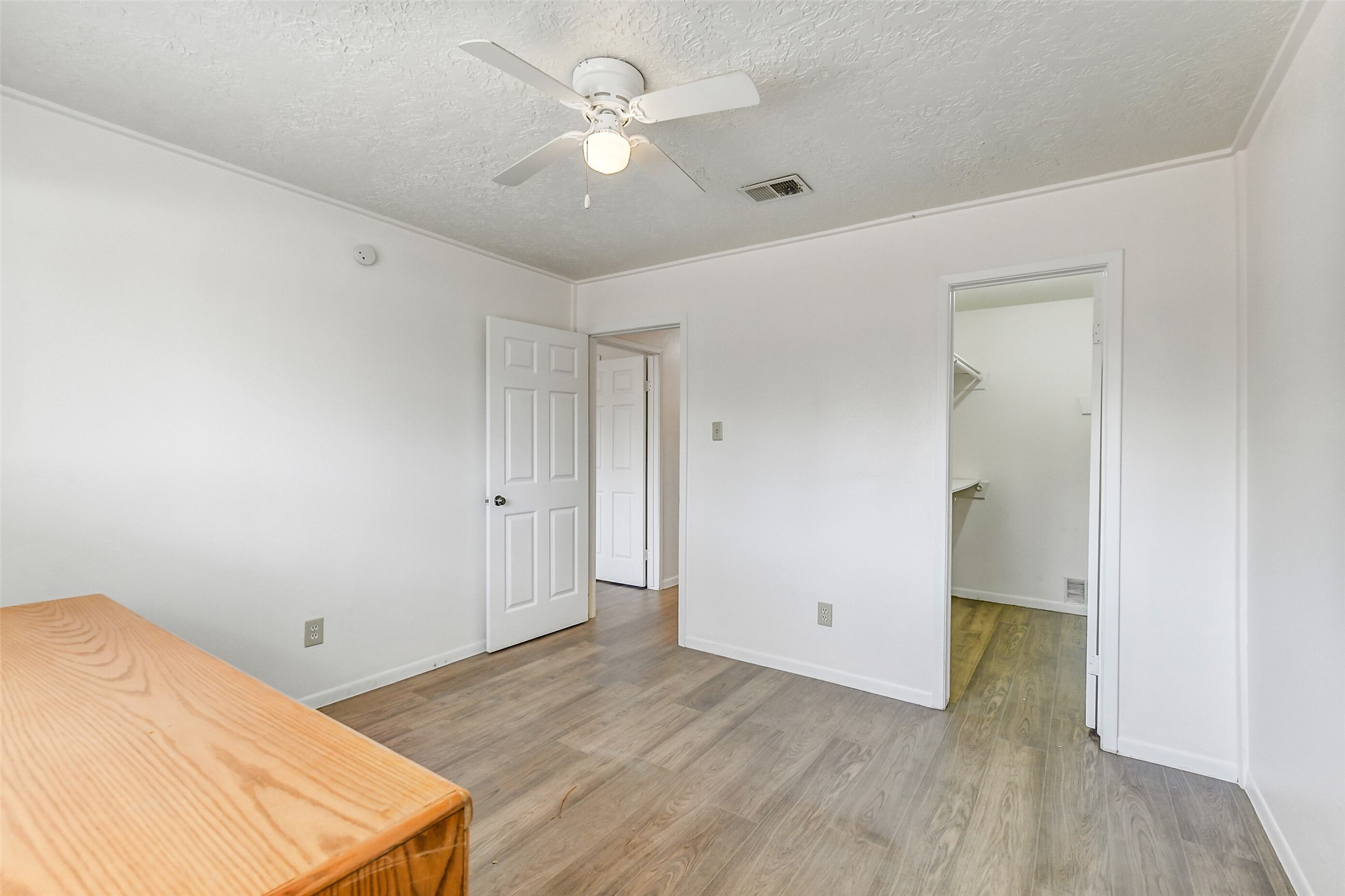 217 Lazy Lane Conroe, TX 77301 - Photo 23 of 28 an empty room with wooden floor and a ceiling fan
