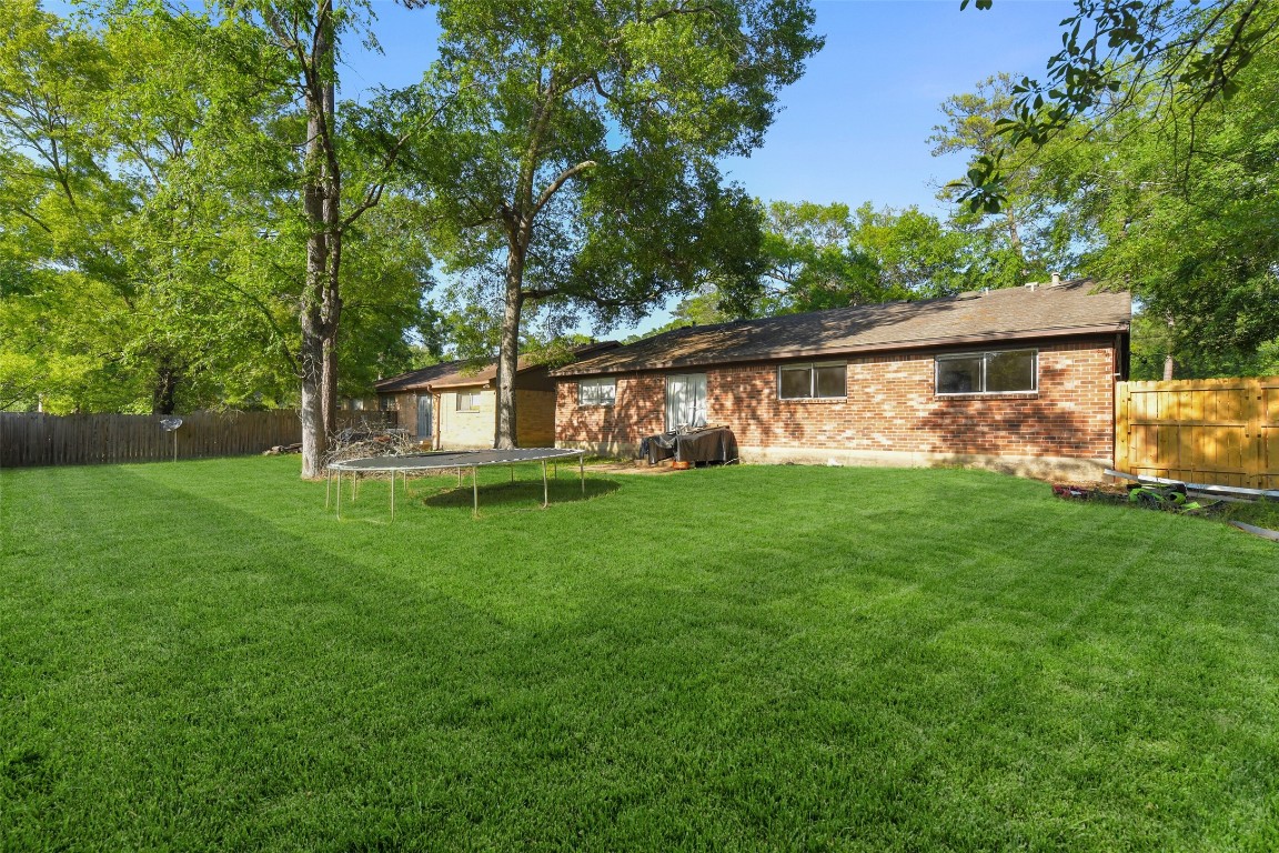 217 Lazy Lane Conroe, TX 77301 - Photo 27 of 28 a view of green field with tree in the background