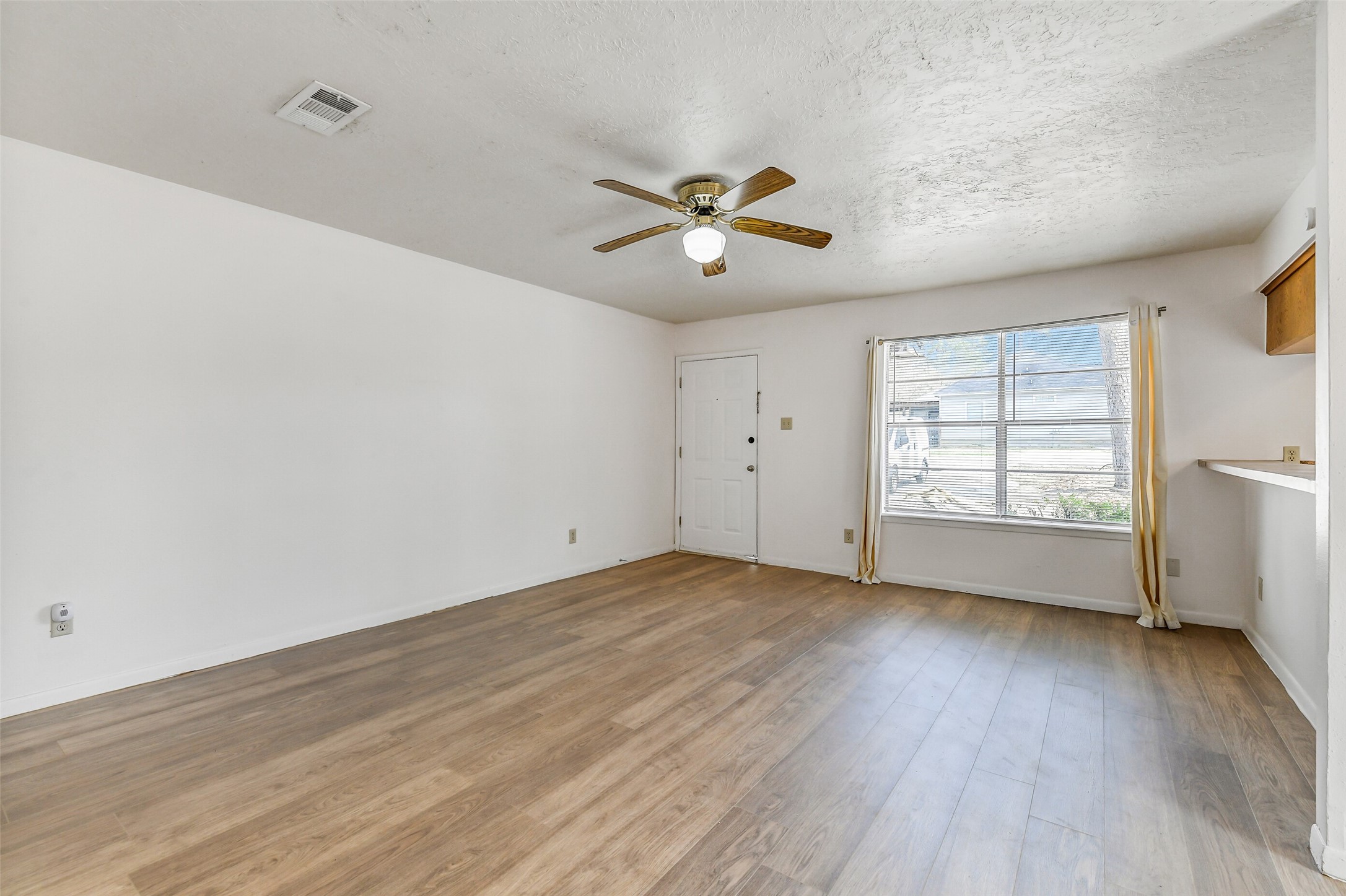 217 Lazy Lane Conroe, TX 77301 - Photo 7 of 28 an empty room with wooden floor and windows