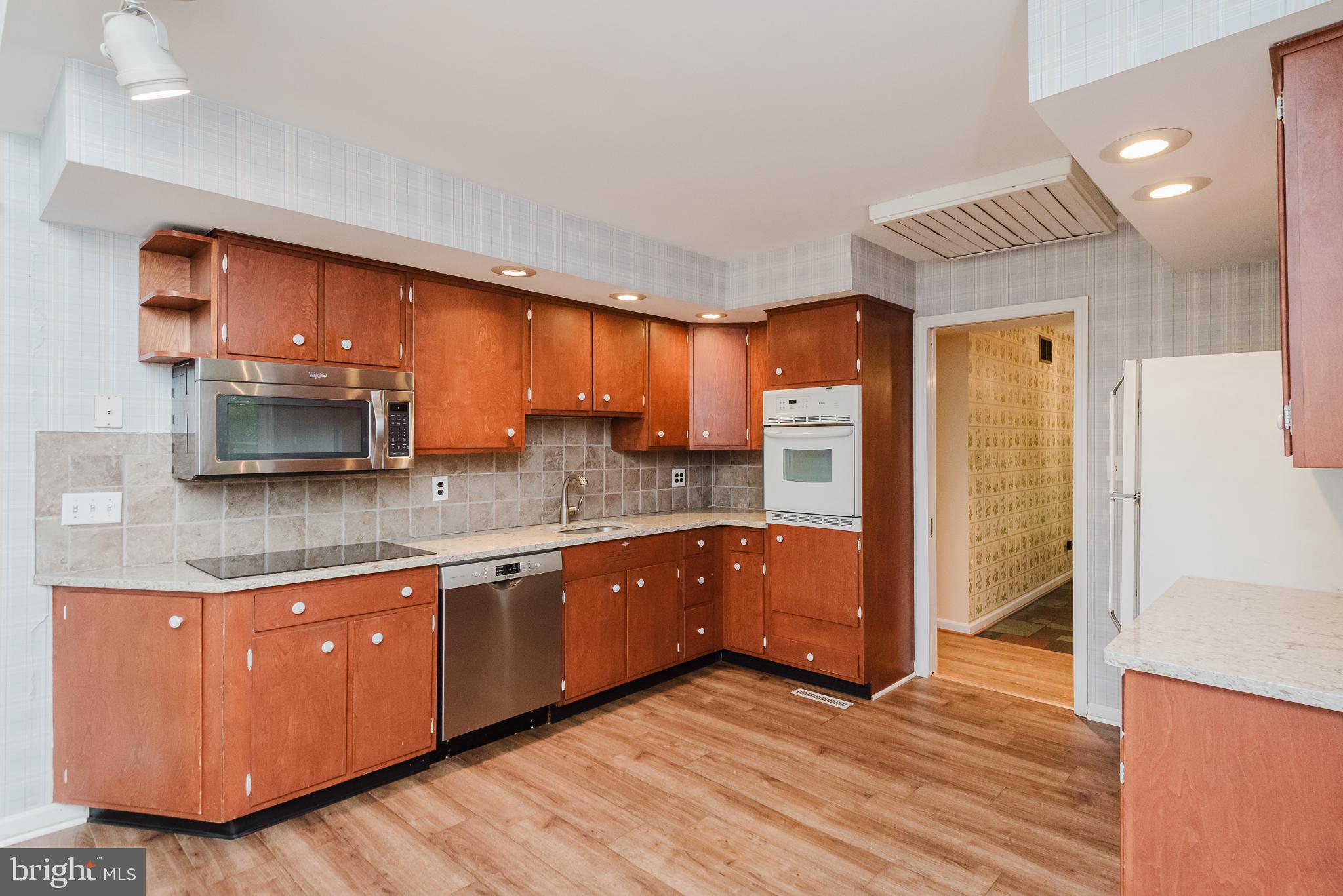 3622 Miller Road Street, MD 21154 - Photo 13 of 48 a kitchen with stainless steel appliances granite countertop a refrigerator a sink and wooden cabinets