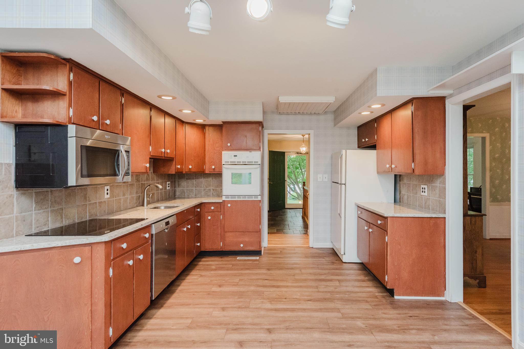 3622 Miller Road Street, MD 21154 - Photo 14 of 48 a large kitchen with stainless steel appliances wooden cabinets and a wooden floor
