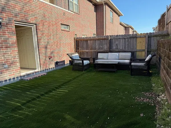 a view of a deck with couches chairs potted plants and wooden fence