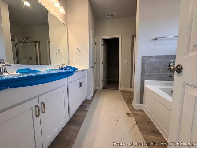 a spacious bathroom with a tub sink and mirror