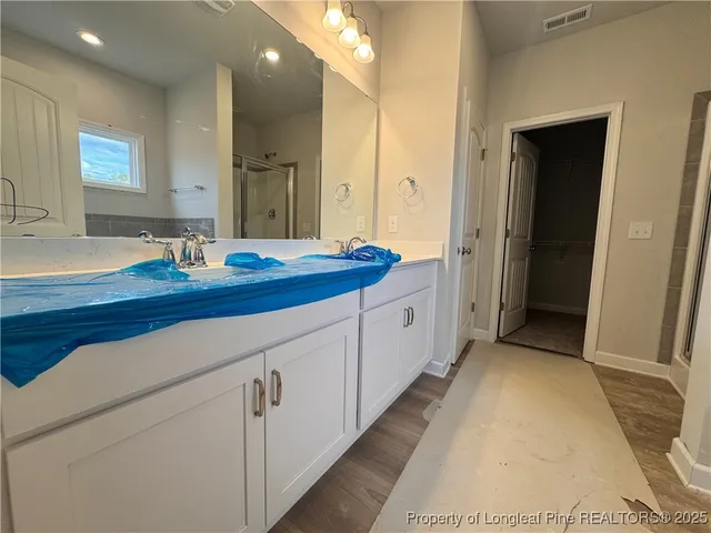 a spacious bathroom with a granite countertop sink mirror and cabinets