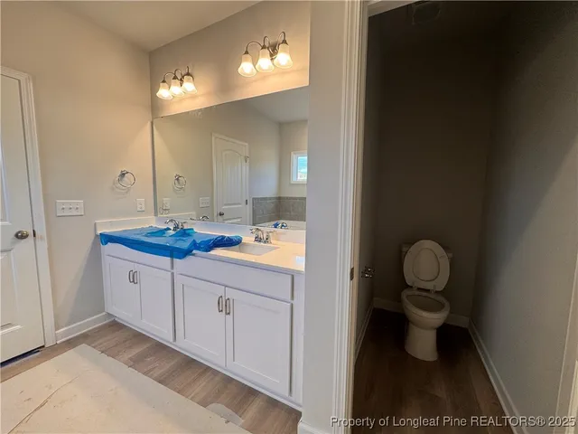 a bathroom with a granite countertop sink a toilet and a mirror