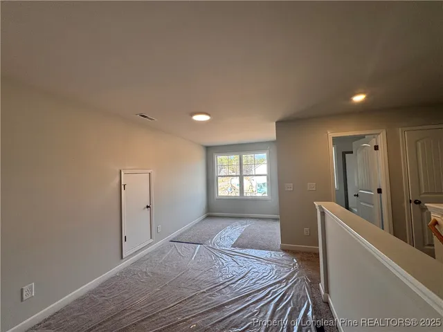 a view of empty room with window and wooden floor