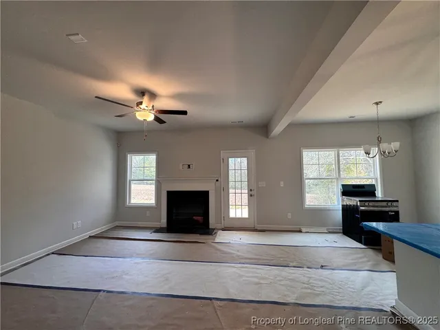 a view of empty room with a fireplace and windows