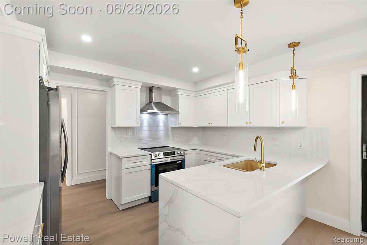 1447 Ravineview Court, Unit C12 Bloomfield Hills, MI 48304 - Photo 24 of 49 Modern kitchen featuring white shaker cabinetry, stainless steel appliances, a white tile backsplash, and quartz countertops