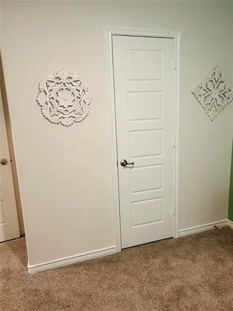 a walk in closet with wooden floor