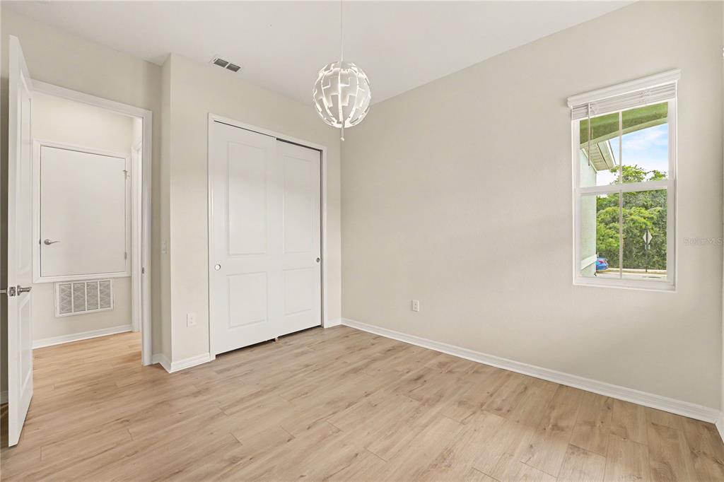1991 Key Bay Trail Kissimmee, FL 34747 - Photo 19 of 31 an empty room with wooden floor chandelier and windows