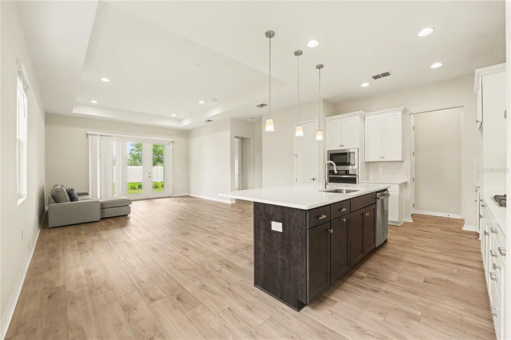 1991 Key Bay Trail Kissimmee, FL 34747 - Photo 8 of 31 a large kitchen with stainless steel appliances granite countertop a large counter top and wooden floors