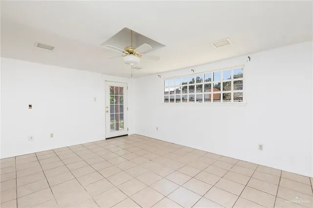 a view of empty room with wooden floor and window
