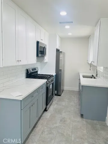 a kitchen with stainless steel appliances a sink and a refrigerator