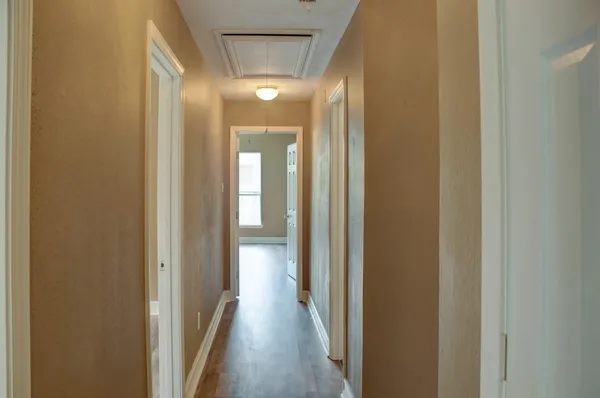 a view of a hallway with wooden floor