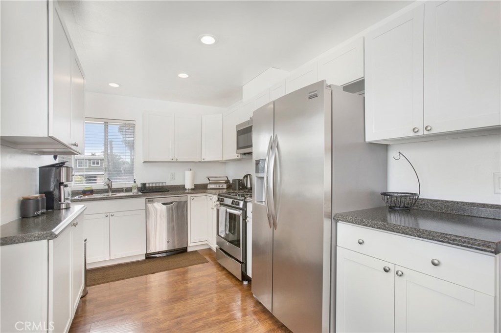 140 Avenida Algodon, Unit C San Clemente, CA 92672 - Photo 4 of 14 a kitchen with stainless steel appliances granite countertop a refrigerator a sink a stove and oven