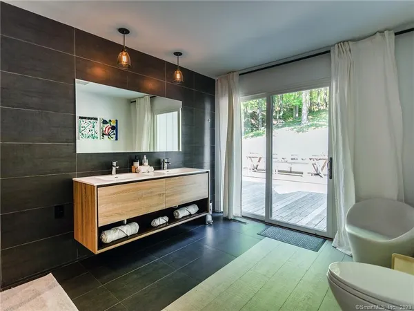 a bathroom with a sink mirror toilet and next to a window