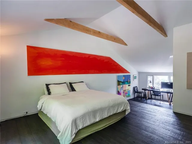 a bedroom with a bed and a dresser next to a window