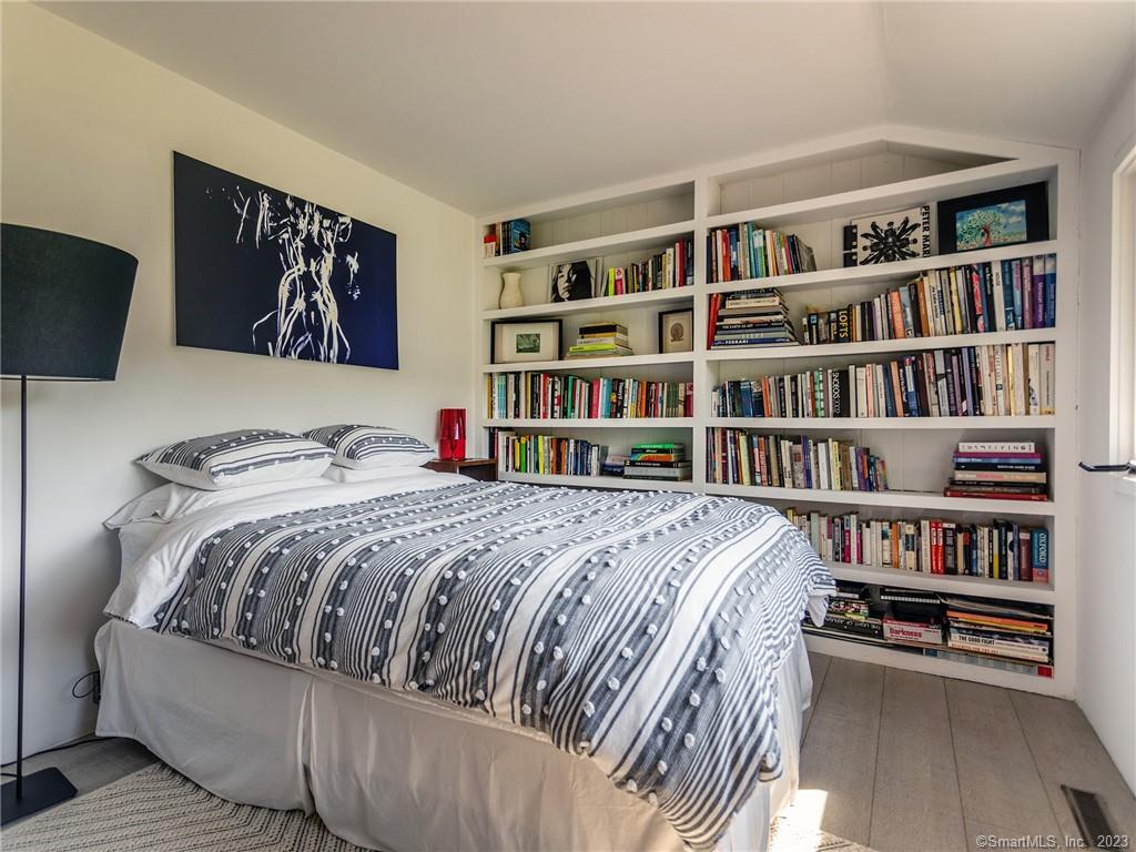 110 Geer Mountain Road Kent, CT 06785 - Photo 31 of 40 a bed sitting in a bedroom next to a book shelf