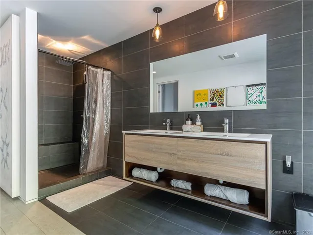 a bathroom with a sink a mirror and a shower