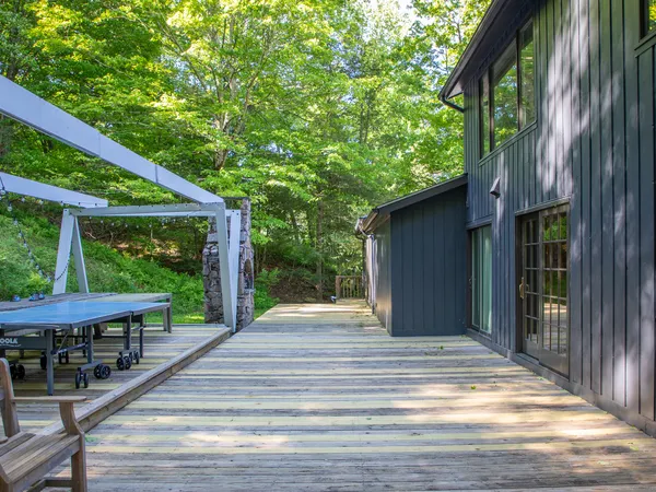 a view of backyard with deck and outdoor seating