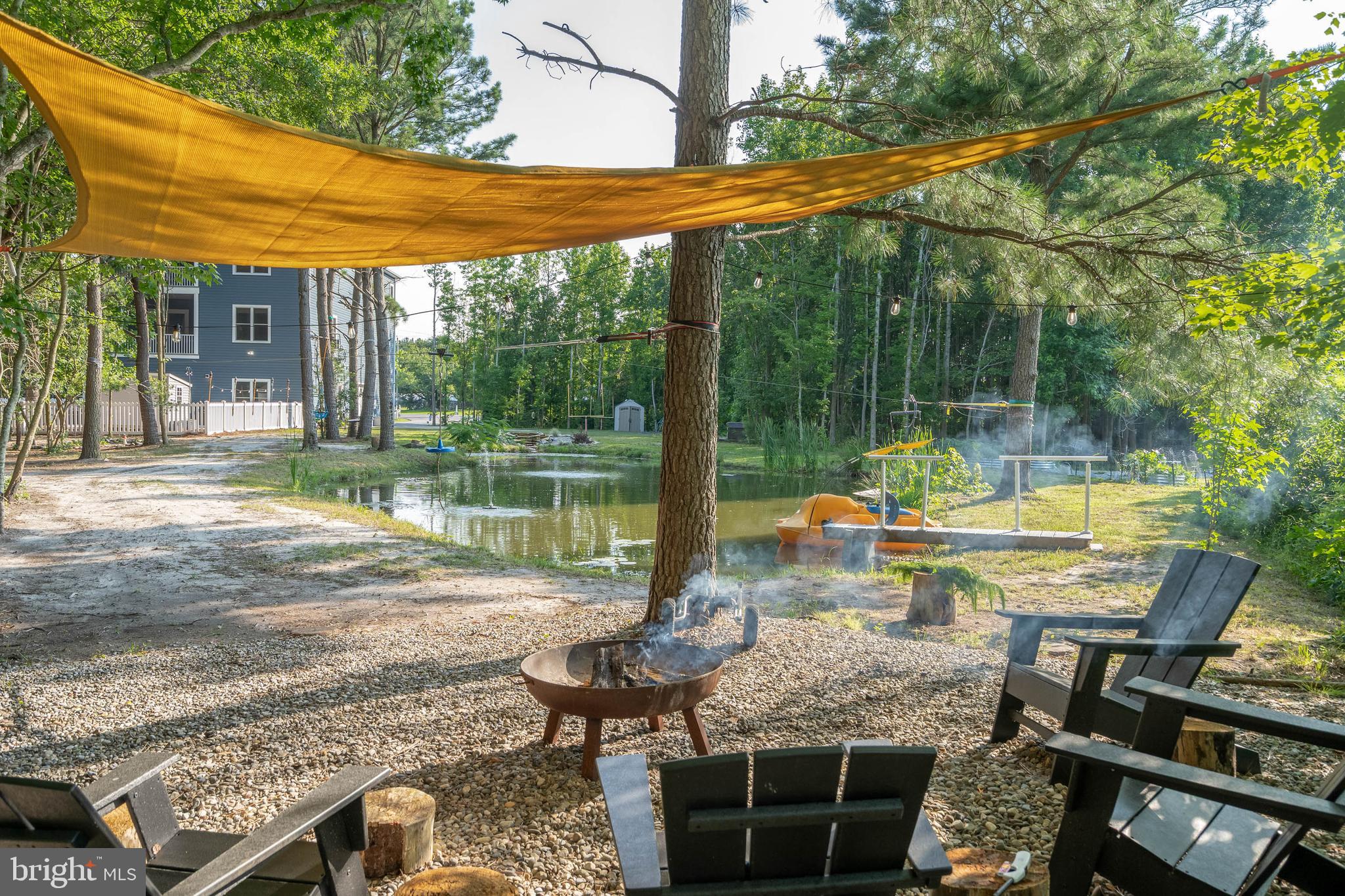 38155 Muddy Neck Road Ocean View, DE 19970 - Photo 46 of 67 a view of a patio with a table chairs and a floor to ceiling window