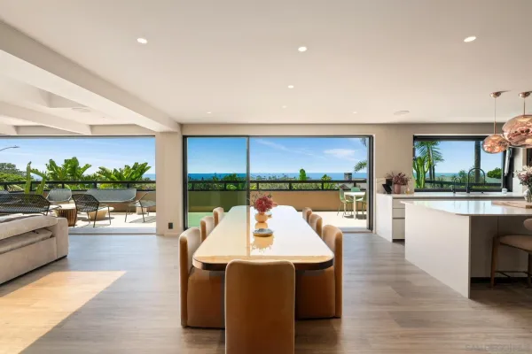 a large white kitchen with a stove a sink dishwasher and a fireplace with wooden floor