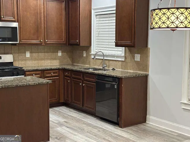 a kitchen with a sink a stove and cabinets