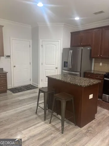 a kitchen with granite countertop a table chairs sink and cabinets