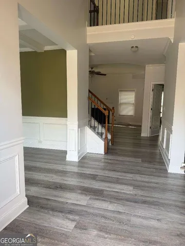 a view of entryway bedroom and hall with wooden floor